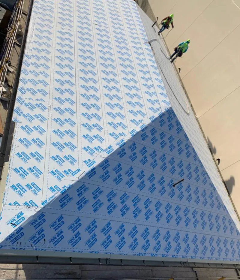 Professional roofers installing underlayment on a metal roof in Arab